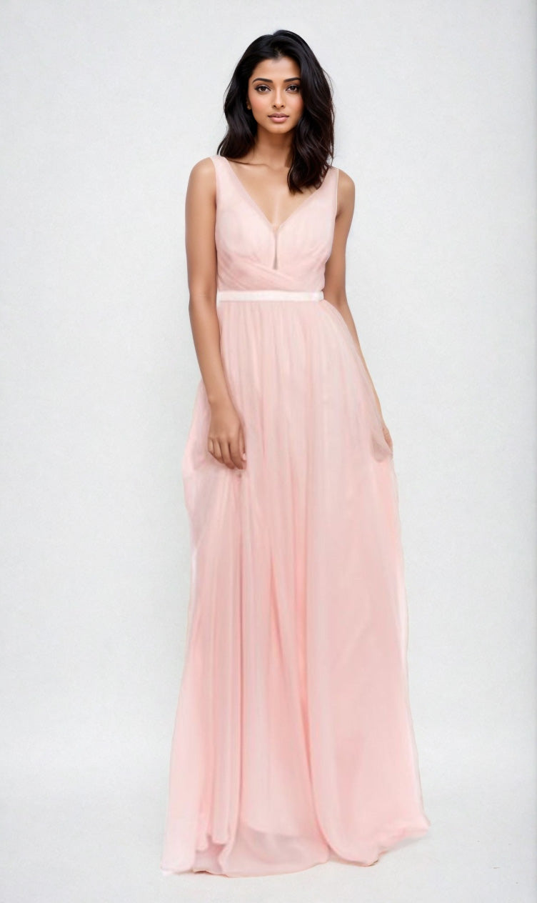 A woman poses against a light background in the Deep V-Back Long A-Line Prom Dress: Chicas C7818, a sleeveless, floor-length gown in light pink with a V-neckline.